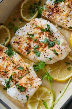 baked fish with lemons and herbs in a pan