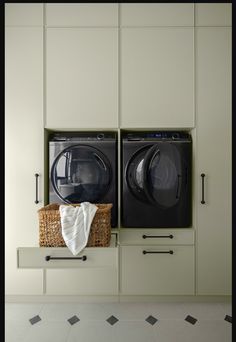 two washers and a dryer sitting on top of each other in a laundry room