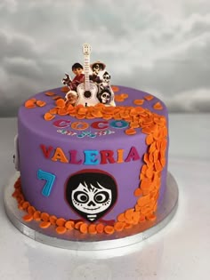 a purple cake with orange and black decorations