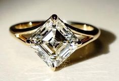 an engagement ring with a princess cut diamond in the center and two black bands around it