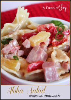 a bowl filled with pasta and ham on top of a table