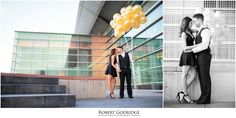 a couple standing next to each other in front of a building and holding yellow balloons