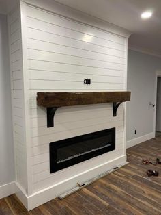 the fireplace is being installed in the living room with wood flooring and white walls