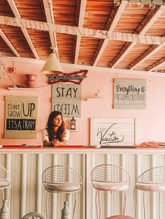 the interior of a restaurant with chairs and signs on the wall above it, along with an image of a woman