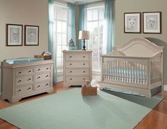 a baby's room with white furniture and blue curtains