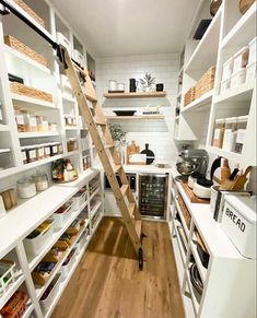 a kitchen with white shelving and wooden flooring