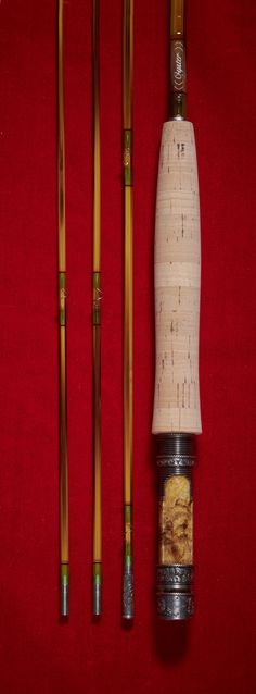 three different types of chopsticks on a red surface with two wooden sticks and one bamboo stick