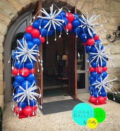 an arch decorated with red, white and blue balloons