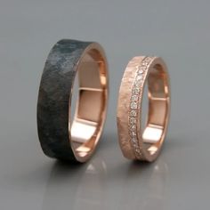 two wedding bands with diamonds on each side and one in the middle, set against a gray background