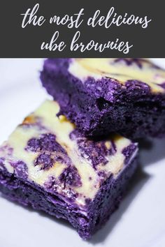 two pieces of purple cake sitting on top of a white plate next to green leaves