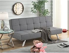 a living room with a gray couch and a teddy bear