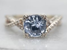 an engagement ring with a blue diamond in the center and two white diamonds on each side