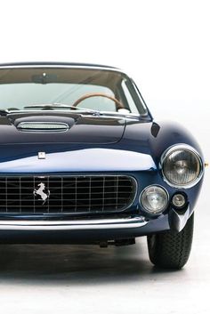 the front end of a blue classic car