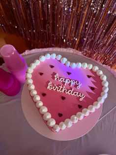 a heart shaped birthday cake sitting on top of a table