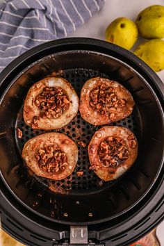 four pieces of bread sitting in an air fryer with apples and pears nearby