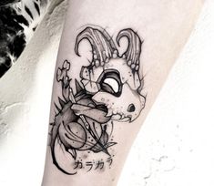 a tattoo on the leg of a person with a dragon head and flowers in it