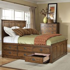 a bed with drawers underneath it in a bedroom