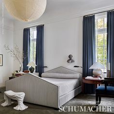 a white bed sitting next to a window in a bedroom