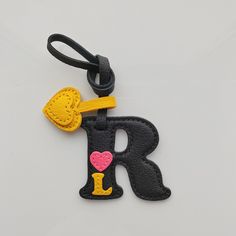 a black and yellow keychain with the letter r on it's side