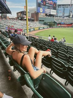 a woman sitting in the stands at a baseball game