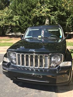 a black jeep is parked in a parking lot