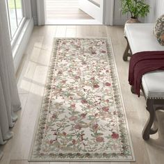 a white rug with red and green flowers on it in front of a door way