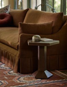 a living room with a couch, table and pillows on the floor in front of it