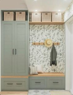 an entryway with green cabinets and baskets on the wall next to it is decorated in neutral colors