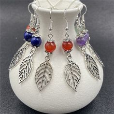 three pairs of earrings with leaves and beads