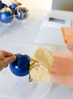 a person is peeling apart an ornament on a piece of tin foil to make it look like they are holding something in their hand