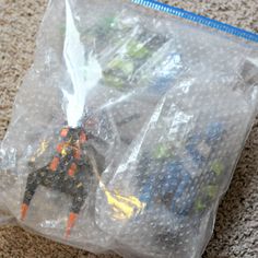 plastic bags filled with toy figurines sitting on the floor