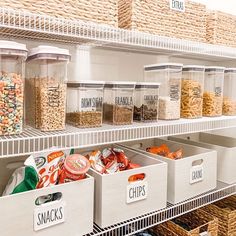 several bins with food in them are on the shelves next to baskets and containers