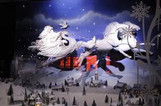 a christmas display with white horses and sleighs