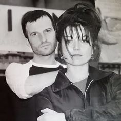 black and white photograph of two people standing next to each other with their arms around one another