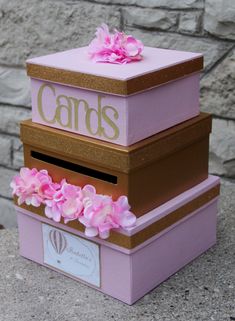 a pink and gold box with flowers on the top that says candles in front of a brick wall