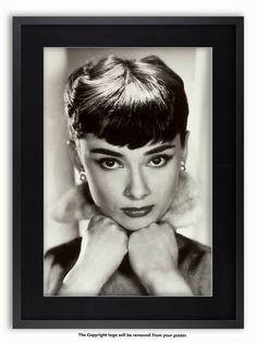 a black and white photo of a woman with her hands on her chin, looking at the camera