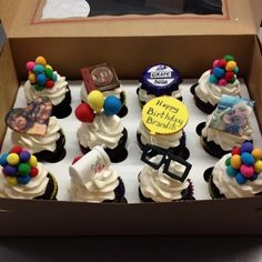 a box filled with cupcakes covered in white frosting and colorful candies