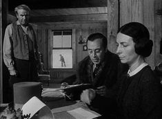 three people sitting at a table in a room