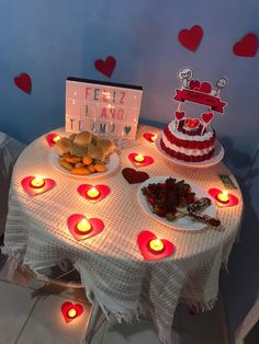 a table topped with plates of food and lit candles next to a sign that says feliz navid time