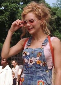 a woman in overalls talking on a cell phone