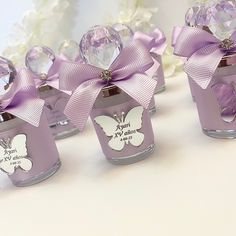 small glass vases with purple bows and butterflies on them