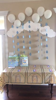 a bed with blue and white balloons hanging from the ceiling