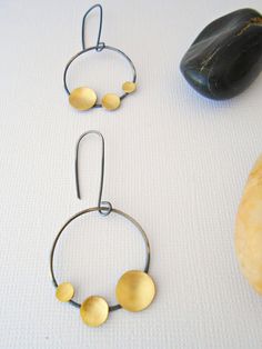 Oxidized sterling silver earrings with brass. This is my unique twist on hoops. Brushed brass discs were added to the darkened silver for contrast. Perfect for the modern, contemporary lover. * Earrings measure 2 inches long and 1 inch at its widest point ** Great gift for a special person or loved one in your life Thank you for stopping by! A reminder that any item can possibly be altered to your specifications or something worked to your favor and almost all items can be custom ordered, so ple Modern Hand Forged Circle Hoop Earrings, Modern Brass Earrings With Oxidized Finish, Minimalist Brass Earrings With Oxidized Finish, Modern Gold Earrings With Oxidized Finish, Gold Minimalist Earrings With Oxidized Finish, Lover Earrings, Unique Hoop Earrings, Oxidized Silver Earrings, Earrings Circle