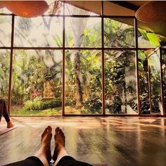 the person is doing yoga in front of large windows