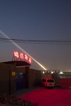 an airplane is flying in the sky above a building with red lights on it's roof