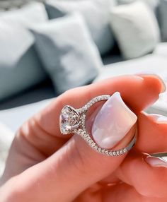 a woman's hand holding a diamond ring