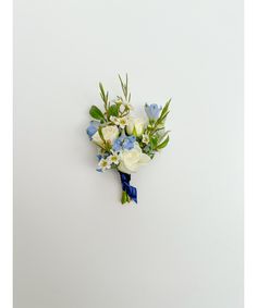 a bouquet of flowers on a white background with blue ribbons and greenery in the center