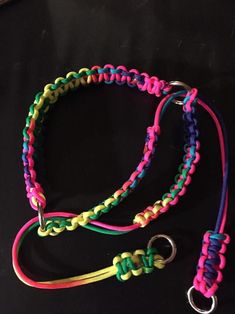 two different colored bracelets on a black background, one has a metal hook and the other has a loop