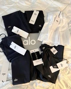 black and white clothes are laid out on a bed with tags attached to the clothing