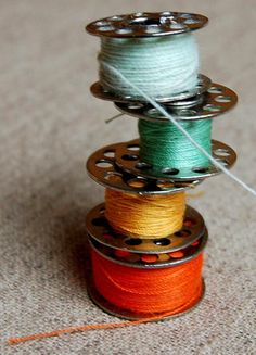 three spools of thread sitting on top of each other